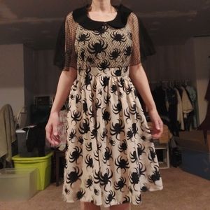 A spaghetti strap, cream satin mid length vintage style dress with cute spiders